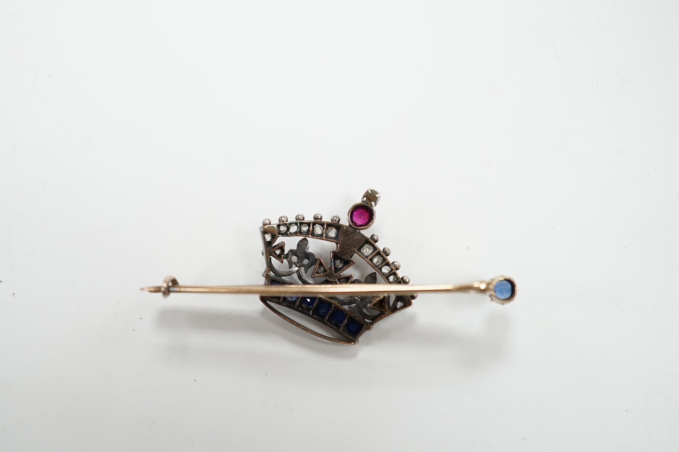 An Edwardian yellow metal, ruby, sapphire and rose cut diamond set coronet bar brooch, 50mm, gross weight 5.8 grams.